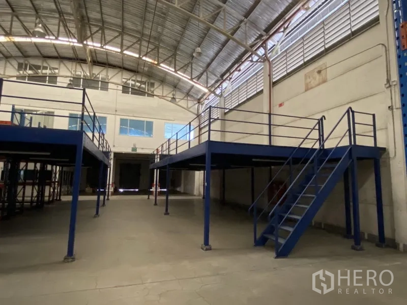 Warehouse for rent in Bang Phli, Samut Prakan - Steel mezzanine platforms with stairs inside a high-ceiling, well-ventilated warehouse.