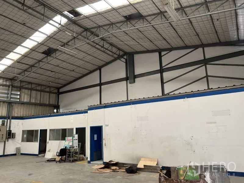 Warehouse for rent in Suan Luang, Bangkok - Internal offices with windows beneath the steel roof structure inside the warehouse.