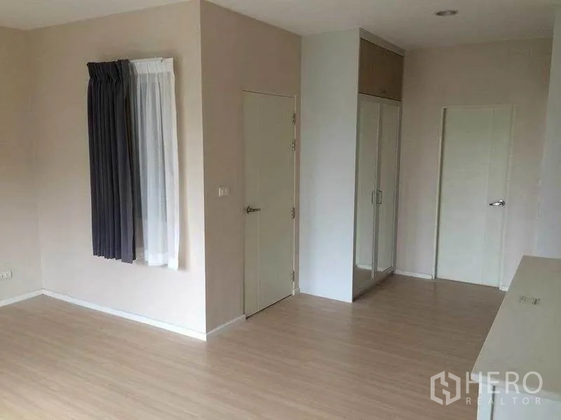 Townhouse for sale in Suan Luang, Bangkok - Bright empty bedroom with light wood flooring, closet and two interior doors.