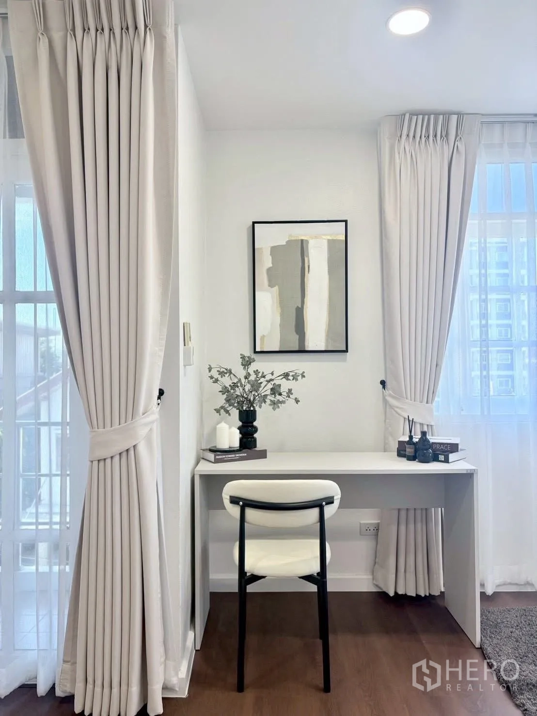 Townhouse for rent in Huai Khwang, Bangkok - Bright study nook with white desk and chair between tall windows.