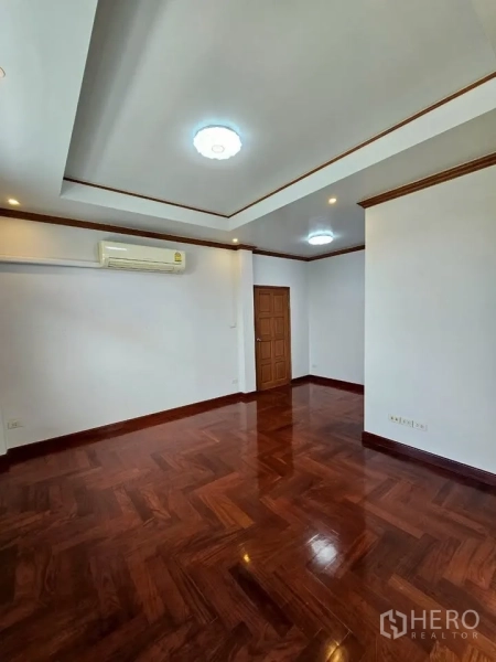 Home Office for rent in Wang Thonglang, Bangkok - Spacious room with recessed lights, AC unit, wooden door and polished wood floors.