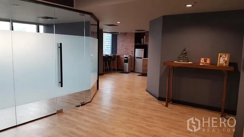 Office Space for rent in Khlong Toei, Bangkok - Office lobby with glass partition leading toward a pantry with brick accent wall in a contemporary layout.