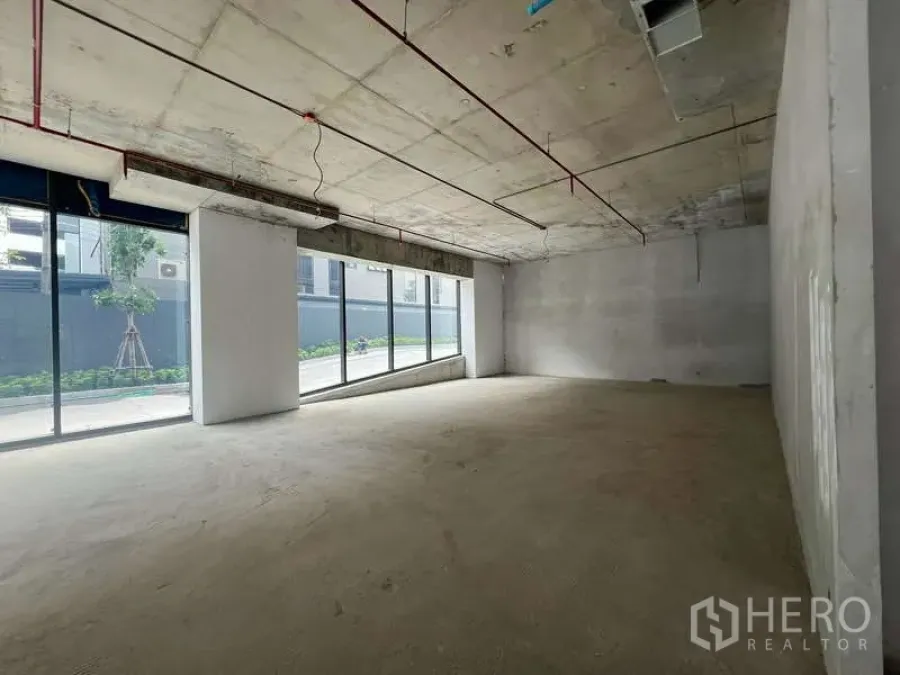 Retail Space for rent - Shell-condition retail space with high concrete ceiling and expansive floor-to-ceiling glass frontage in Phaya Thai, Bangkok.