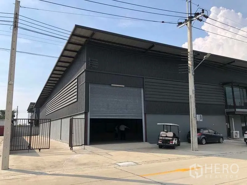 Warehouse for rent in Bang Phli, Samut Prakan - Close view of loading bay with half-open roller door and gated entry at an industrial warehouse.