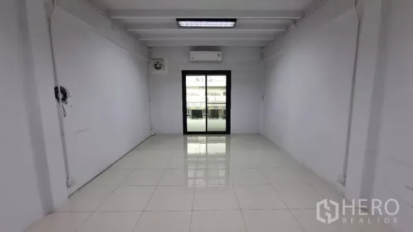 Townhouse for rent in Huai Khwang, Bangkok - Bright room with sliding glass door, air conditioner and white tiled flooring.