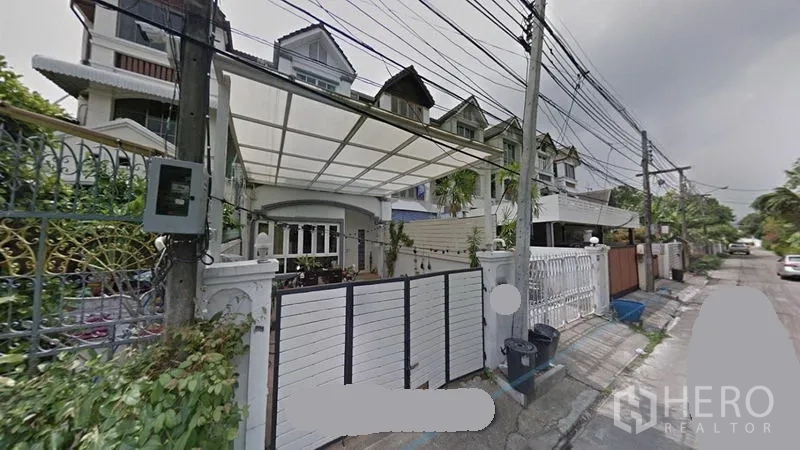 Townhouse for rent or sale in Khlong Toei, Bangkok - Front facade of a multi-storey townhouse with gated carport and awning on a quiet lane in Khlong Toei.