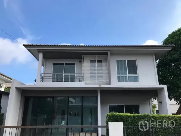 Detached House for rent in Bang Na, Bangkok - Modern two-storey detached house facade with balcony, privacy louvers and large glass doors in Bang Na.