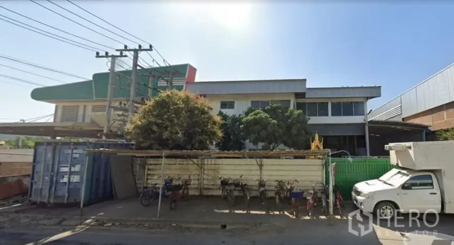 工厂 出售在Khlong Luang, Pathum Thani - 临街工厂正面视角，带停车区，周边为工业环境。