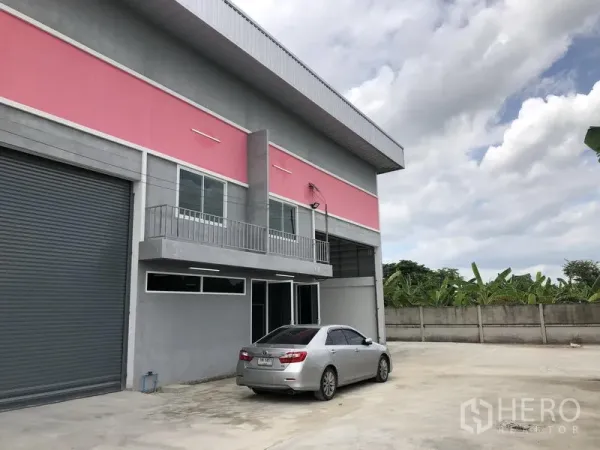 工厂 出租在Sai Noi, Nonthaburi - 转角单元，卷帘门、阳台以及临围墙的大面积停车区。