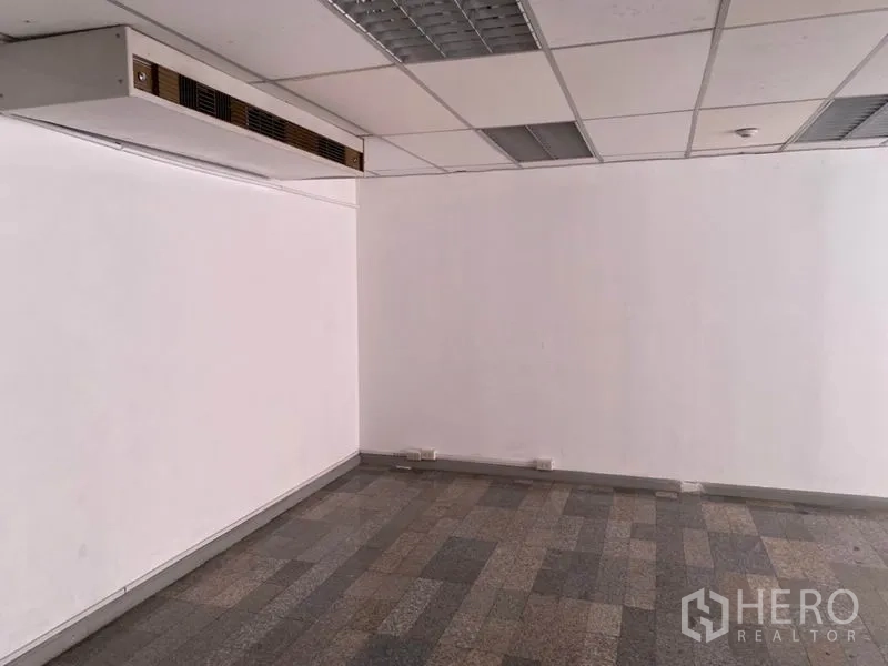 Office Space for rent in Khlong Toei, Bangkok - Empty office room with a suspended ceiling, ducted air-conditioning and gray tile flooring.