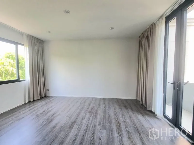 Detached House for rent - Spacious room with floor-to-ceiling windows, balcony doors, curtains and wood-look flooring.