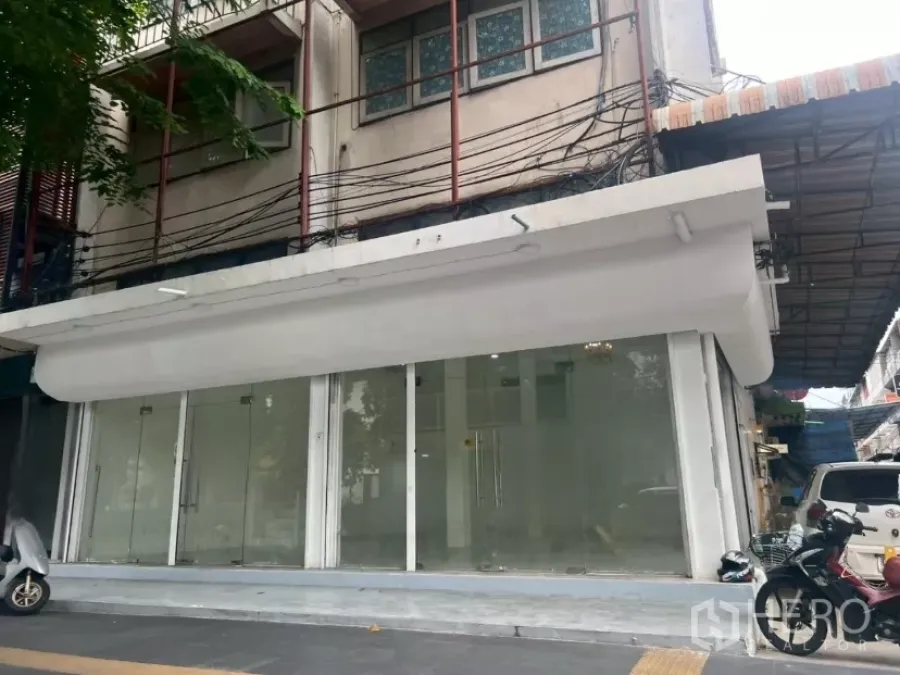 Retail Space for rent in Khlong Toei, Bangkok - Ground-floor retail facade with wide glass storefront and white awning on a Bangkok street.