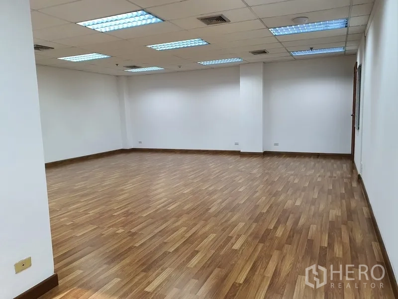Office Space for rent in Watthana, Bangkok - Flexible empty office area with grid ceiling, fluorescent lighting and wood laminate floor.