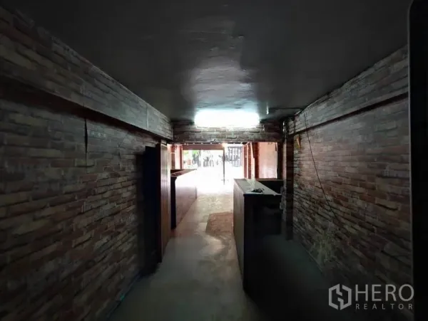 店屋 出租在Khlong Toei, Bangkok - 狭长通道式店面，红砖墙体，通向街边入口。