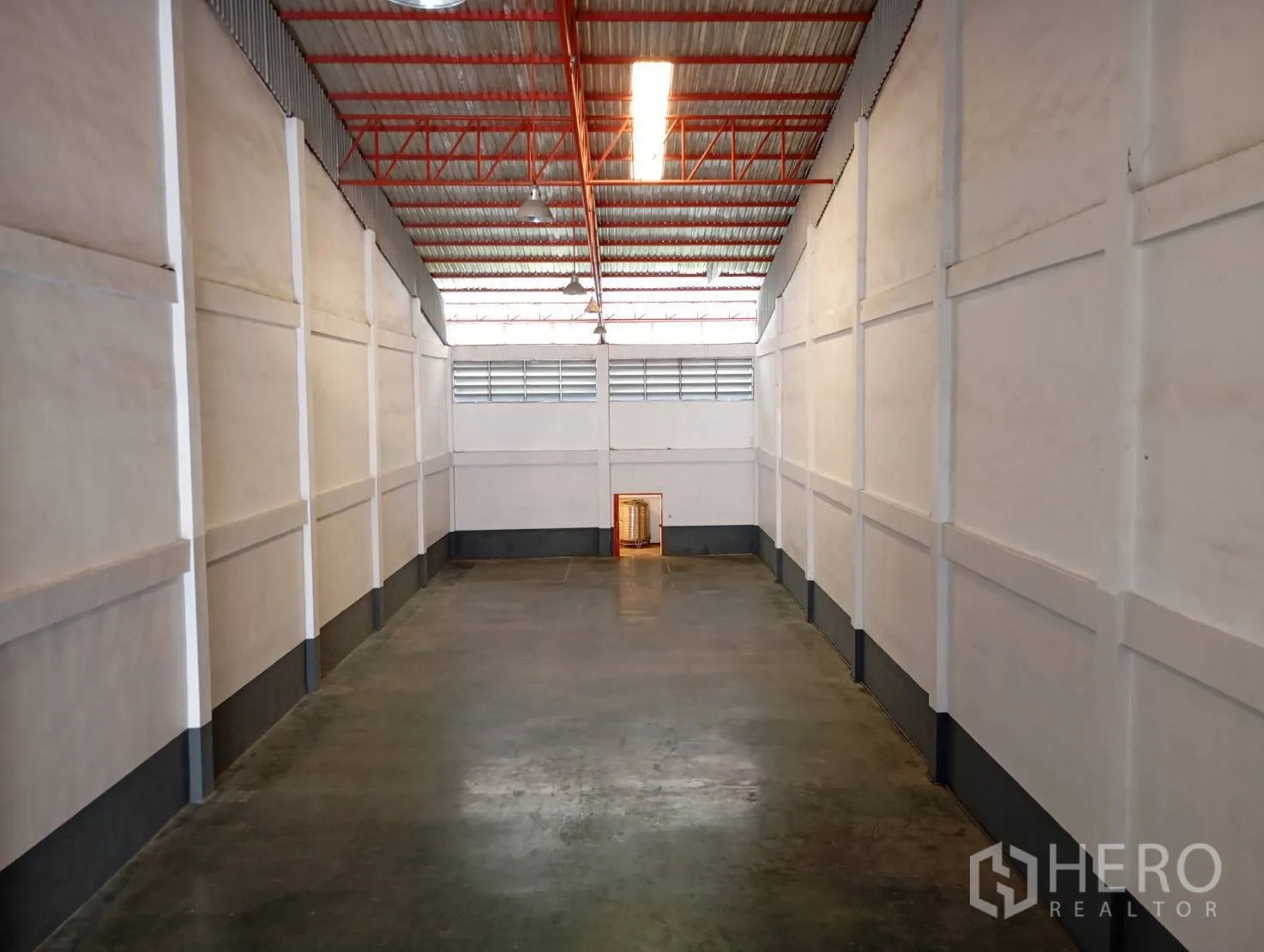仓库 for rent in Bang Phli, Samut Prakan - 细长的仓库通道，混凝土地面，高屋顶与工业灯具。