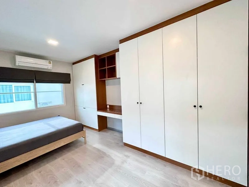 บ้าน ให้เช่าหรือขายในPrawet, Bangkok - มุมมองตู้เสื้อผ้าสูงเต็มผนังและโต๊ะทำงานในห้องนอน