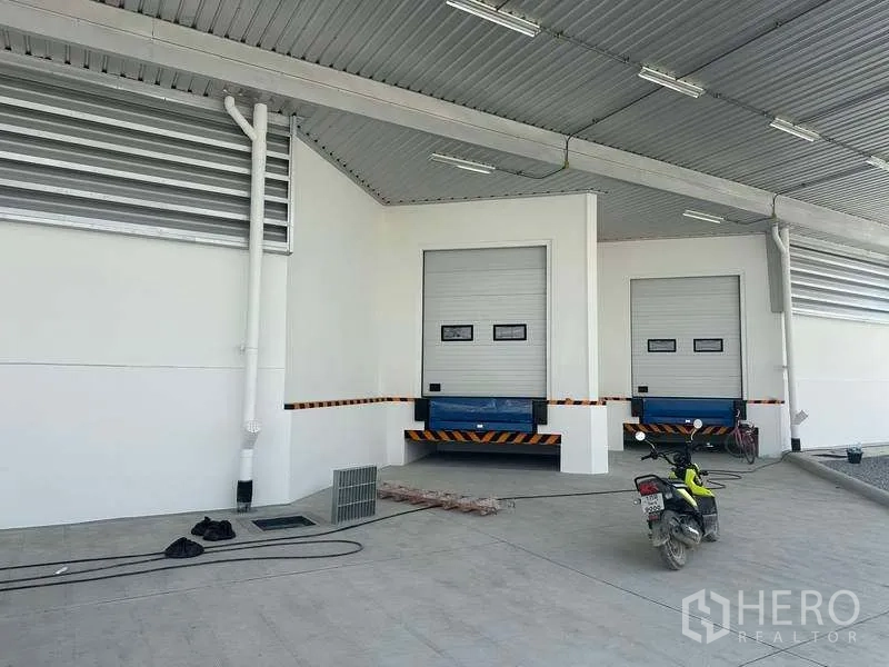Warehouse for rent in Bang Phli, Samut Prakan - Two dock-high loading bays with dock levelers and roller shutter doors under a roof.