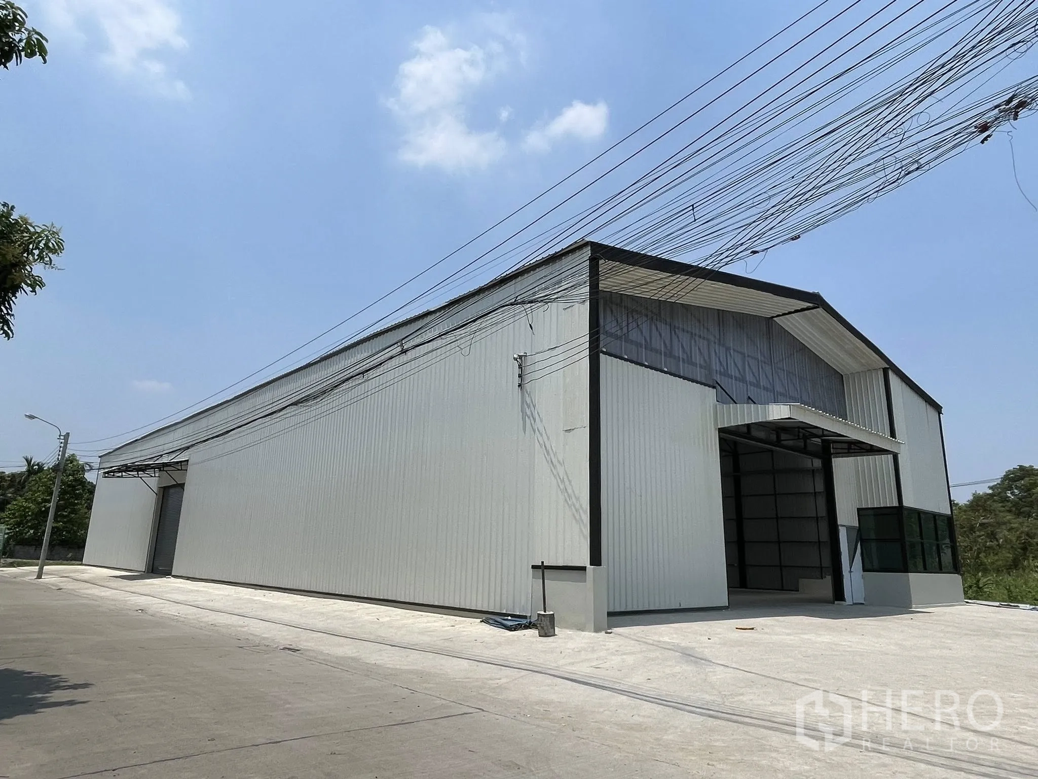 仓库 for rent in Pak Kret, Nonthaburi - 仓库外观，山形屋顶与宽阔混凝土前院。