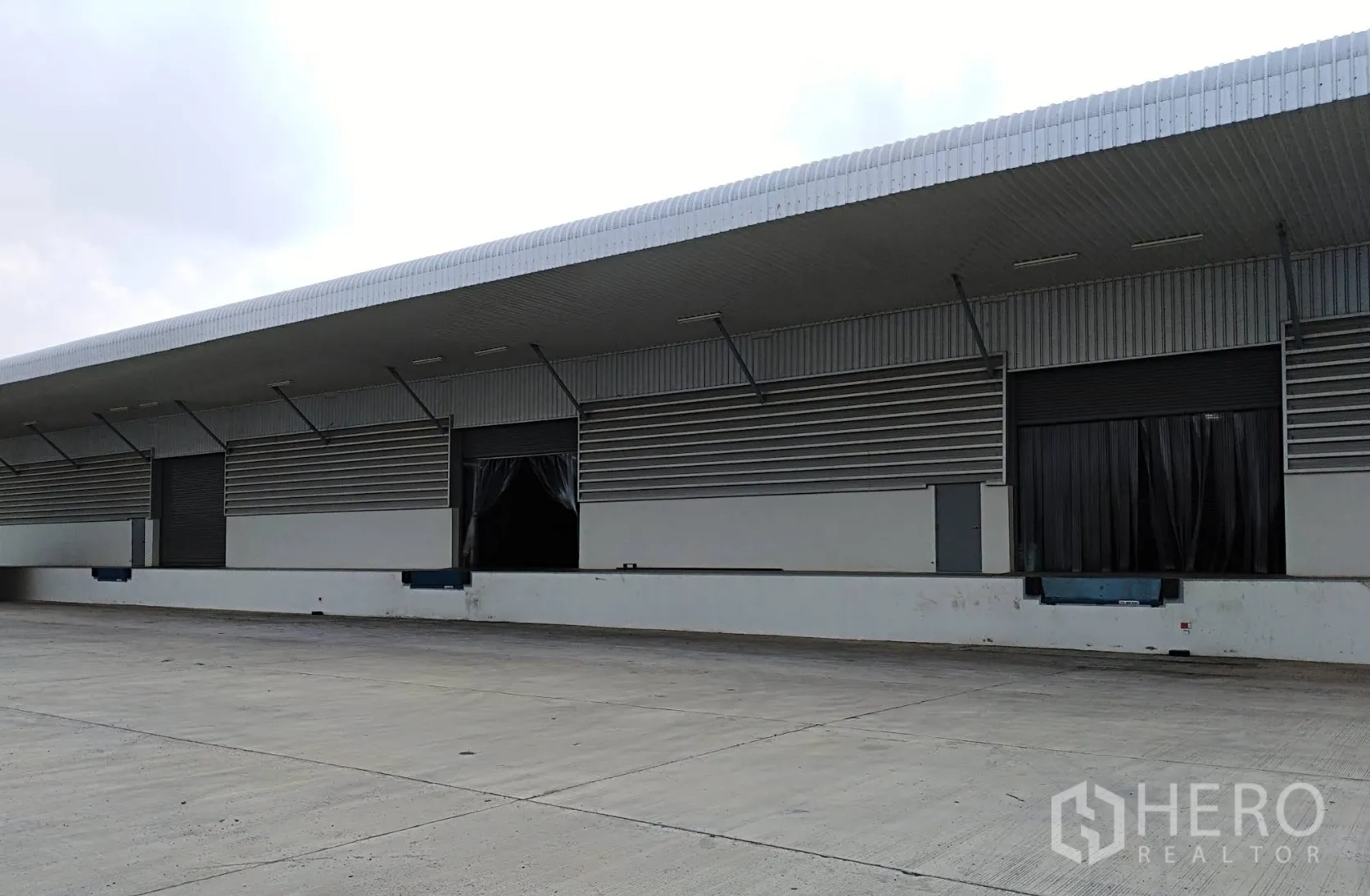 Warehouse for rent in Wang Noi, Phra Nakhon Si Ayutthaya - Exterior loading platform with multiple dock bays, dock levelers, and shutter doors under a wide canopy.
