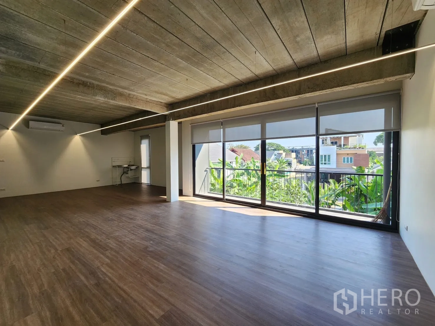Home Office for rent in Chatuchak, Bangkok - Bright office area with full-height sliding doors opening to a balcony and green views.