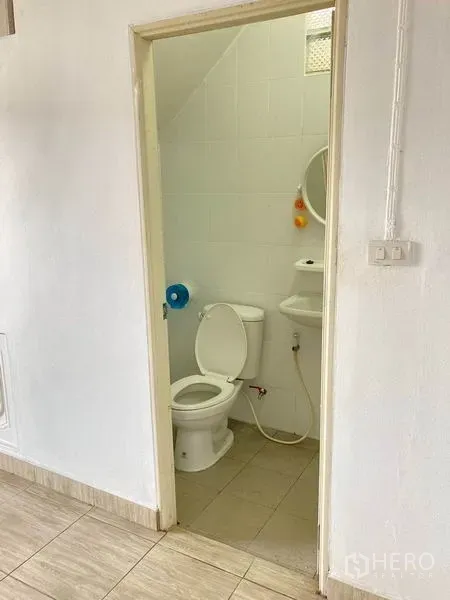 Warehouse for rent in Bang Phli, Samut Prakan - Clean bathroom with toilet, sink and white tiled walls.