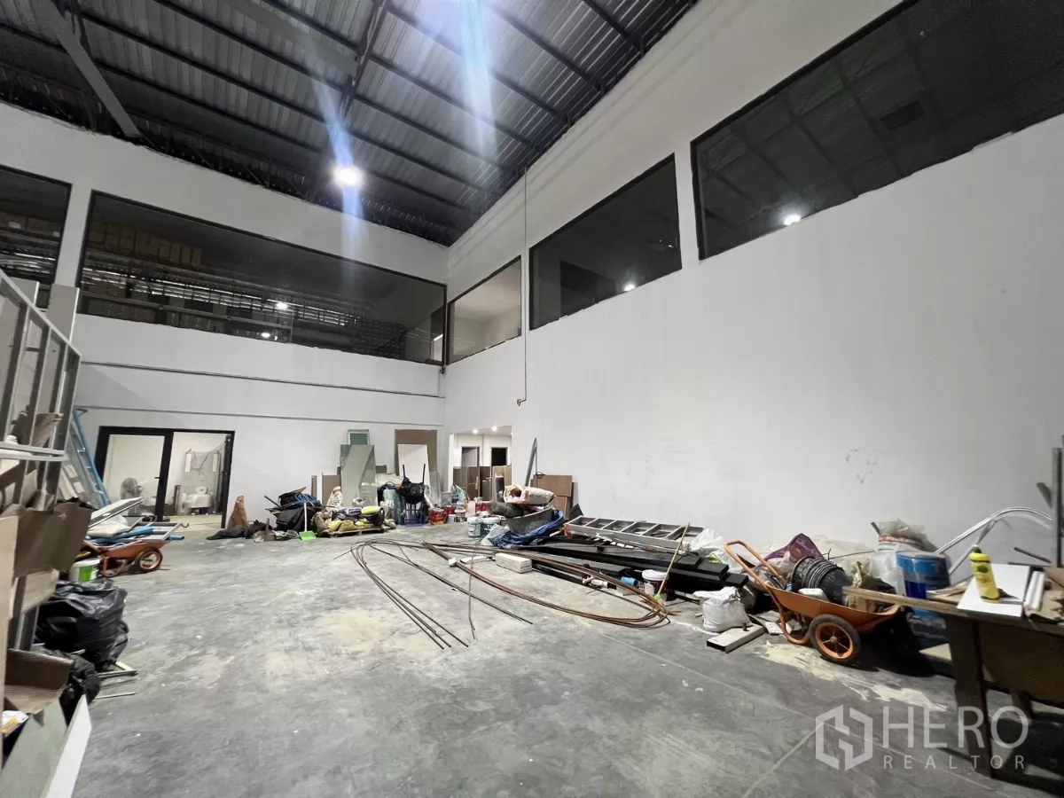 Warehouse for rent or sale in Lat Krabang, Bangkok - Open storage zone with concrete floor, mezzanine level and wide access doors.
