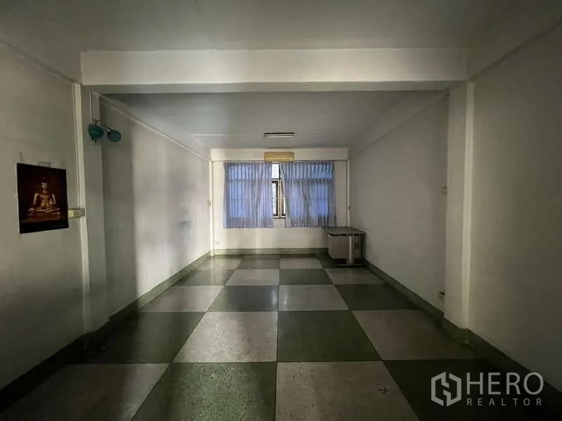 Shophouse for rent in Suan Luang, Bangkok - Long rectangular room with tiled floor and curtained window for office use.