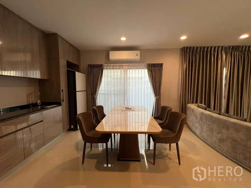 Detached House for rent in Bang Kapi, Bangkok - Dining area with marble-top table seating six next to the pantry.