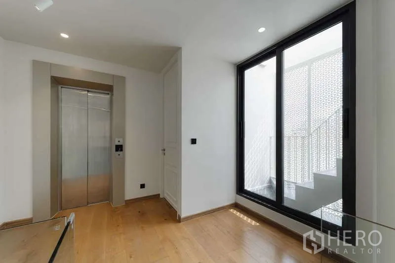 Townhouse for rent or sale in Watthana, Bangkok - Private elevator lobby with large window and access to a balcony staircase.