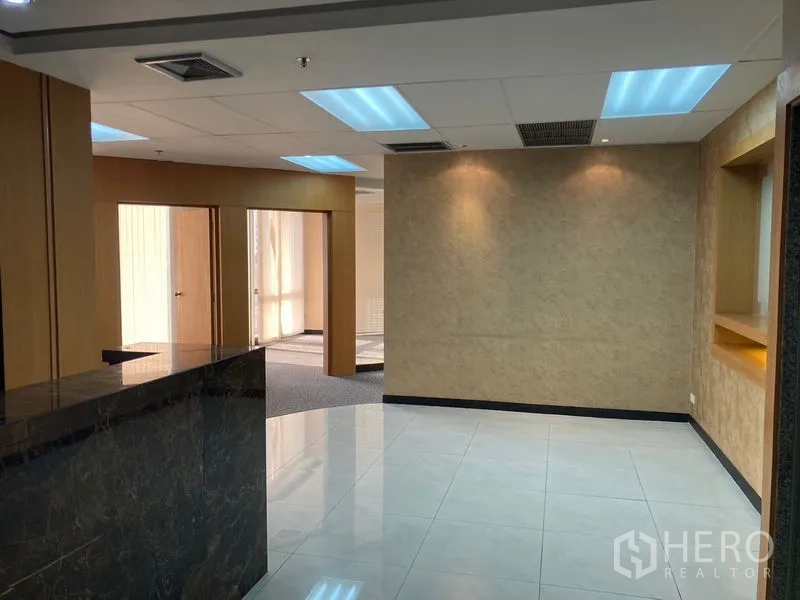 Office Space for rent - Reception zone with polished tile floor, stone counter, accent lighting and access to office rooms.