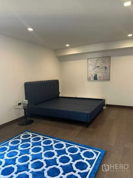 独立式住宅 出租在Suan Luang, Bangkok - 舒适卧室，深蓝平台床与几何图案地毯。