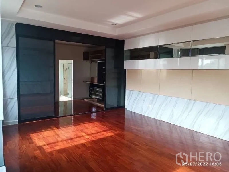 Detached House for sale in Prawet, Bangkok - Bedroom with dark sliding doors opening to a walk-in closet.