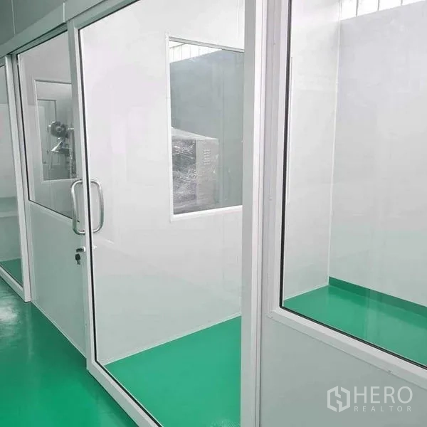 Factory for sale in Bang Pa-in, Phra Nakhon Si Ayutthaya - Clean glass-partitioned room with equipment visible through an interior window.