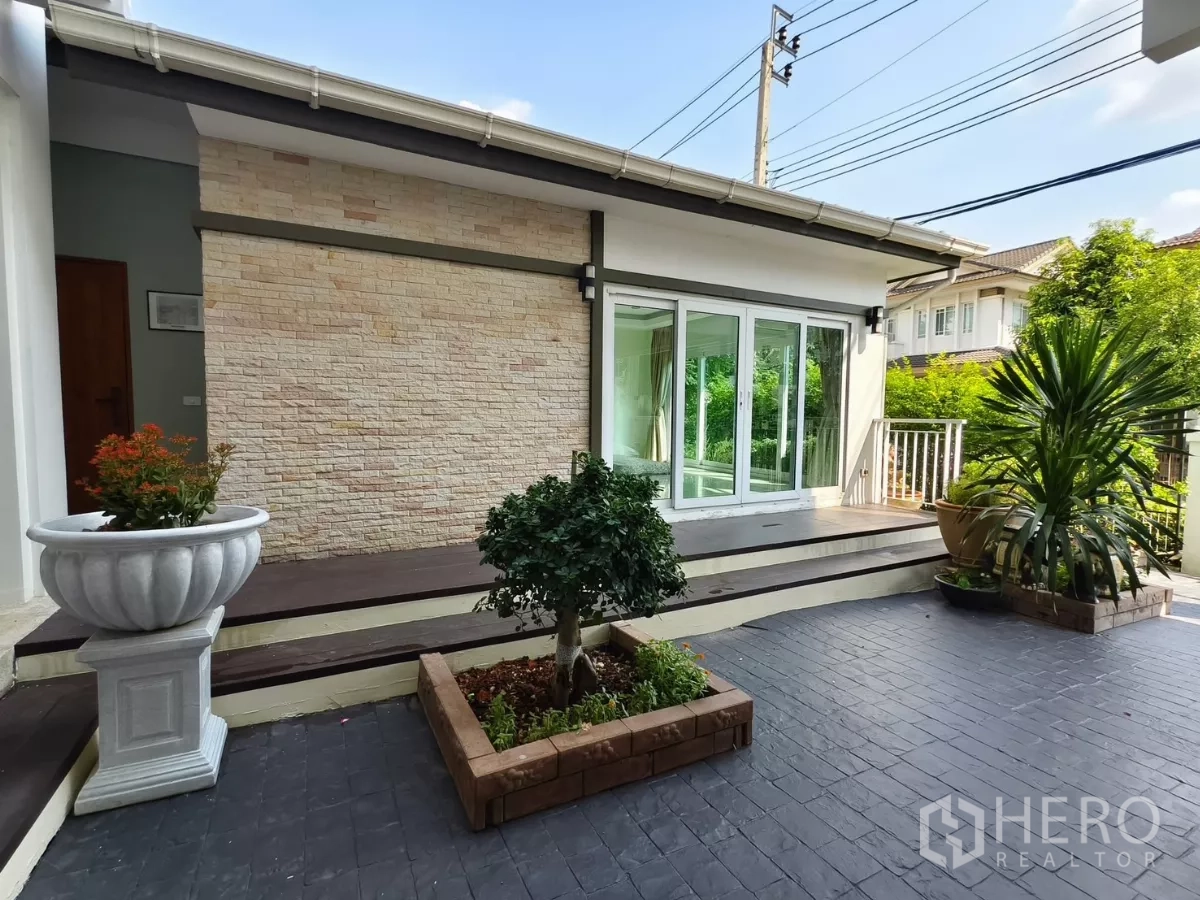 Detached House for rent in Bang Kapi, Bangkok - Front patio with raised deck, sliding glass doors and stone-clad wall.