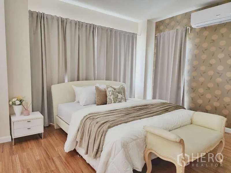 Detached House for rent in Prawet, Bangkok - Master bedroom angle showing a wallpaper feature wall and bedside tables.
