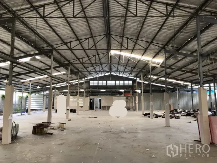 Warehouse for rent or sale in Khlong Luang, Pathum Thani - Central view of the open warehouse highlighting the steel roof structure and ample floor space.