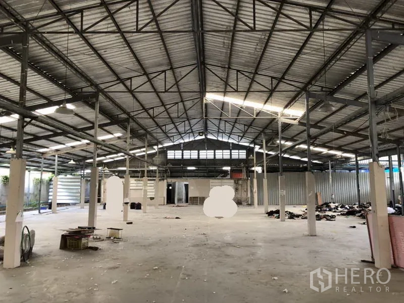 Warehouse for rent or sale in Khlong Luang, Pathum Thani - Central view of the open warehouse highlighting the steel roof structure and ample floor space.