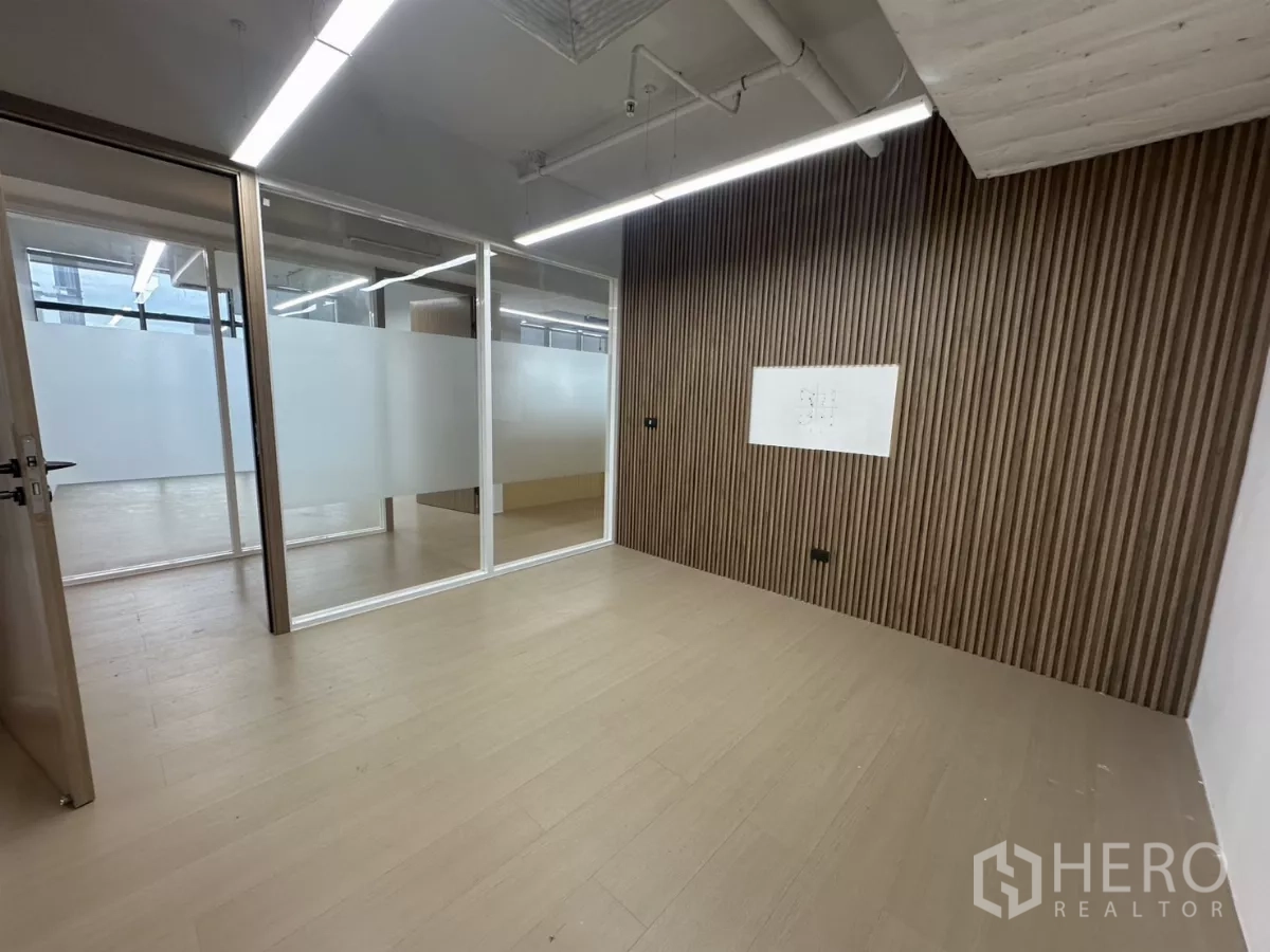 Office Space for rent in Watthana, Bangkok - Private meeting room with wood slat accent wall and frosted glass partitions.