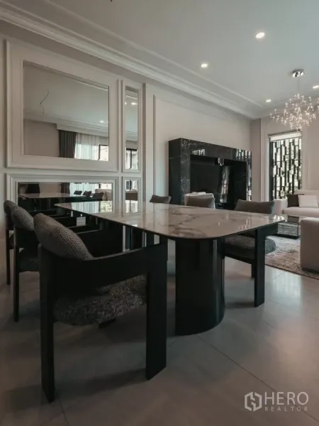 Detached House for rent or sale in Bang Kapi, Bangkok - Contemporary dining area with a marble-top table and upholstered chairs beside the living room.