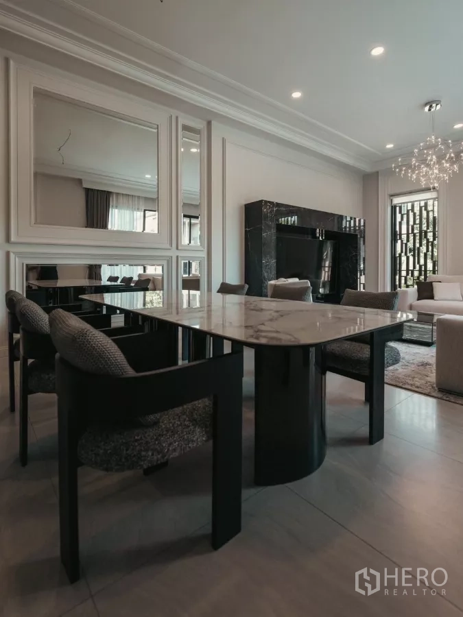 Detached House for rent or sale in Bang Kapi, Bangkok - Contemporary dining area with a marble-top table and upholstered chairs beside the living room.