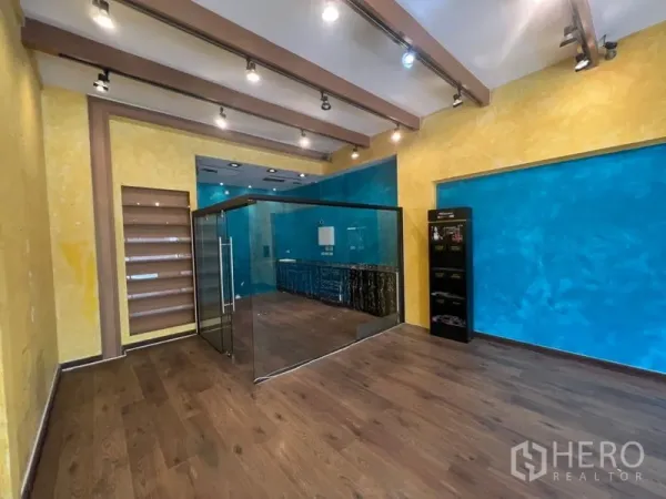 Retail Space for rent in Watthana, Bangkok - Sales area showing glass partition room, display shelving, colorful feature walls, and spotlights.