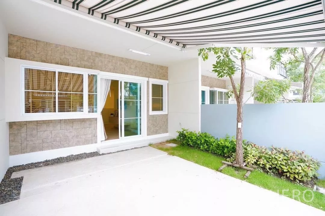 Townhouse for rent in Bang Phli, Samut Prakan - Covered carport and porch with sliding glass doors and a small lawn