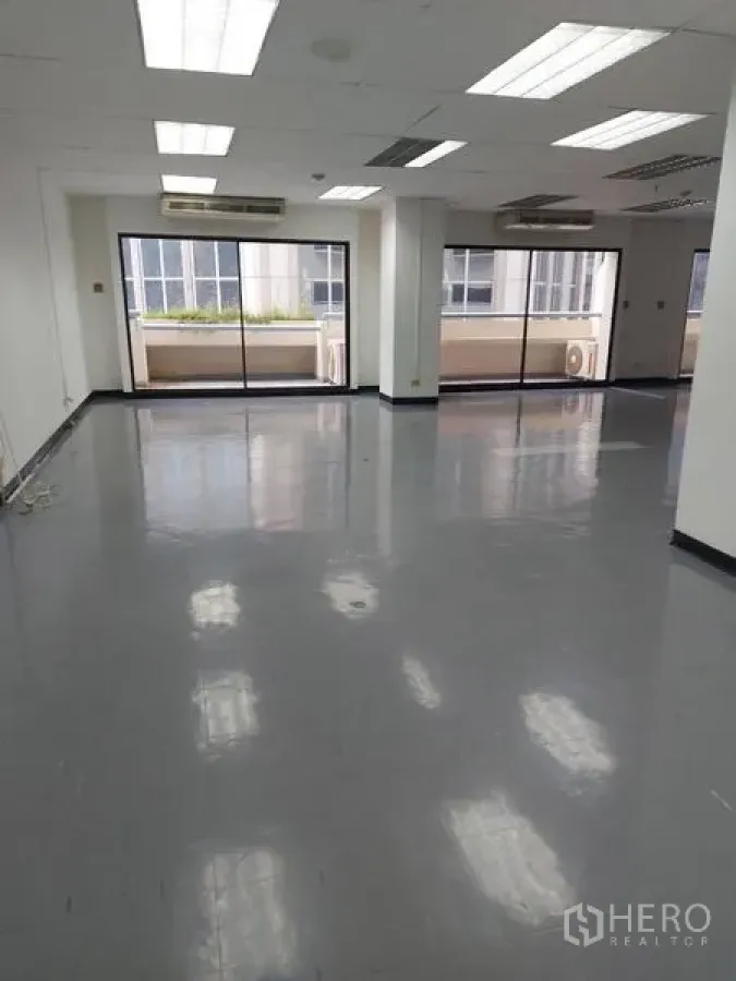 Office Space for rent in Pathum Wan, Bangkok - Open-plan Bangkok office with glossy floors, drop ceiling lights, and large sliding glass doors to a balcony.