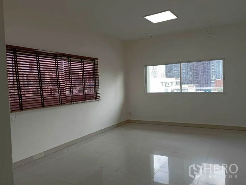 Office Space for rent in Khlong Toei, Bangkok - Spacious workspace featuring twin windows, wooden blinds and polished floors.