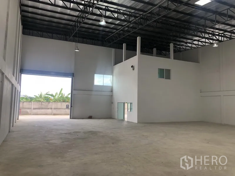 工厂 出租在Sai Noi, Nonthaburi - 仓库另一视角，展示夹层办公室与吊灯照明。