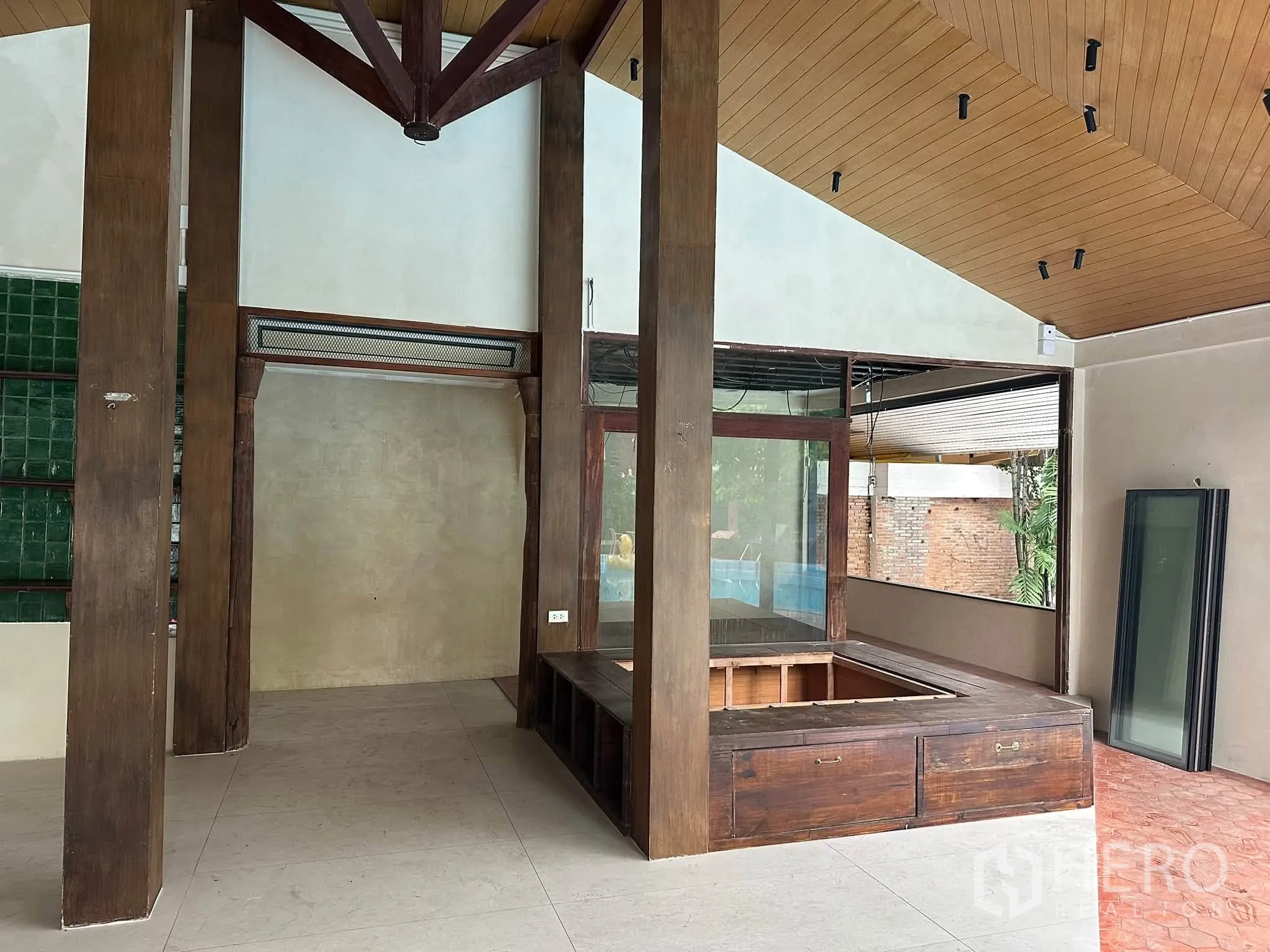 Retail Space for rent in Khlong Toei, Bangkok - Interior with vaulted timber ceiling, wooden pillars, and a built-in counter facing large windows.