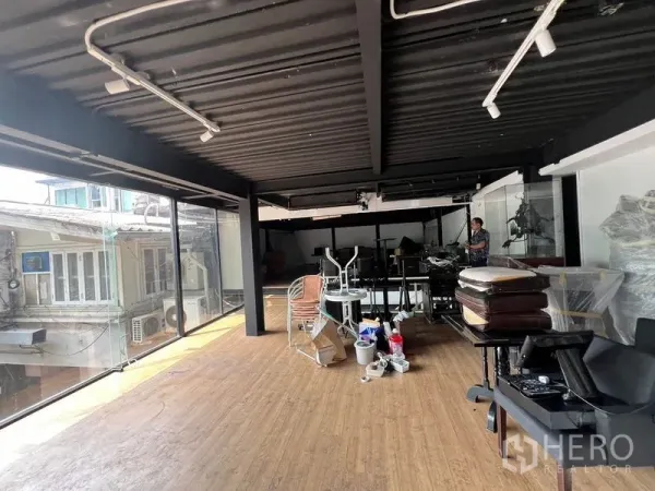 Retail Space for rent - Bright showroom level with full-height glazing, track lighting, and wood flooring in an urban shophouse setting.