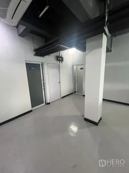 Retail Space for rent in Watthana, Bangkok - Service area with multiple doors for storage or staff rooms beneath exposed ductwork.