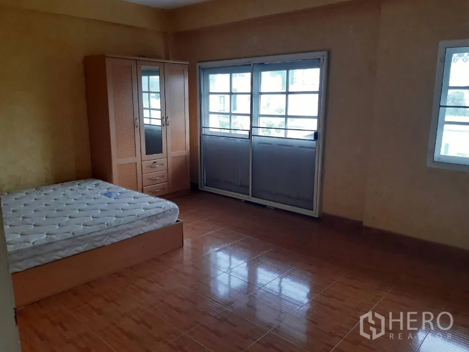 Townhouse for rent in Khlong Toei, Bangkok - Bedroom with large windows and sliding balcony doors, tile floor and closet.