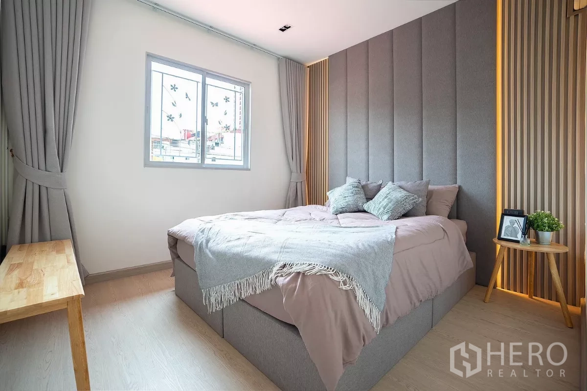 Detached House for rent in Huai Khwang, Bangkok - Another angle of the bedroom showing large bed and paneled feature wall.